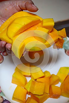 Peel the mango on a plate in the kitchen