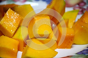 Peel the mango on a plate in the kitchen