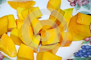 Peel the mango on a plate in the kitchen