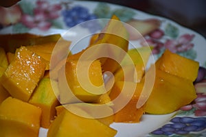 Peel the mango on a plate in the kitchen