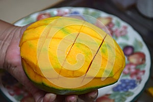 Peel the mango on a plate in the kitchen
