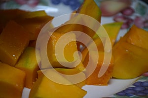 Peel the mango on a plate in the kitchen