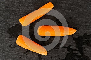 Peeled baby carrot on grey stone