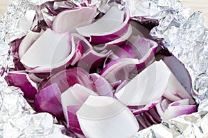 Peeled and chopped red onions in tin foil