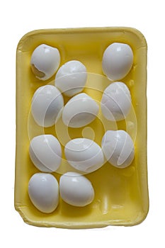 Peeled eggs lie in a yellow packing box, a meager Breakfast on a white background, isolated