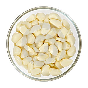 Peeled garlic cloves in glass bowl, from above