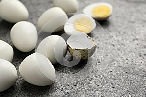 Peeled hard boiled quail eggs on grey table, closeup