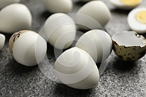 Peeled hard boiled quail eggs on grey table, closeup