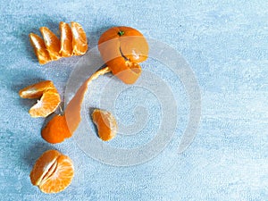 Peeled mandarin without peel and slices of ripe mandarin are on the table