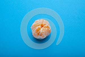 Peeled mandarin tangerine isolated on a blue background