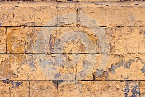 peeled off old orange paint on flat rough brick wall surface - full frame background and texture