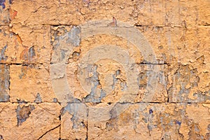 peeled off old orange paint on flat rough brick wall surface - full frame background and texture