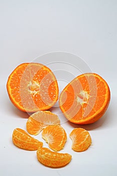 Peeled orange and mandarin slices on white isolated background