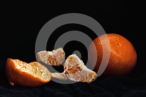 Peeled orange with slices and peel, mystical light