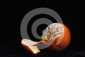 Peeled orange with slices and peel, mystical light