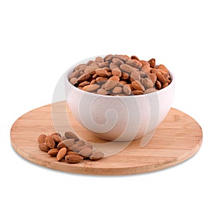 Peeled organic almond nuts in white bowl on wood board isolated on white background, copy space.
