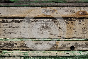 Peeled paint over wood boards from a boat hull, green and white painted on wooden boards, traces of time, old wood texture traces