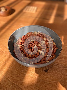 Peeled Peanuts in Bowl with Wooden Surface