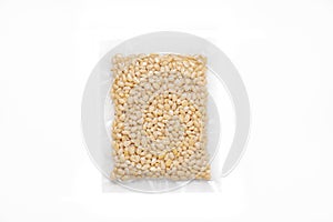 Peeled Pine Nut In Transparent Vacuum Plastic Packaging On White Background
