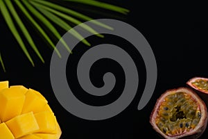 Peeled pineapple, bamboo and passion fruit. Fresh Tropical Fruits. On a black background. Top view. Copy space