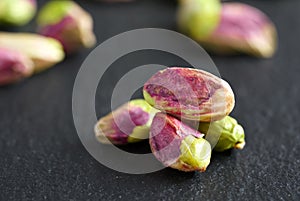 Peeled pistachios on the black stone board