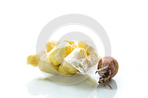 Peeled potatoes closed in a vacuum bag and old sprouted potatoes