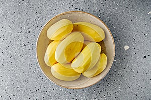 Peeled potatoes on a gray stone background