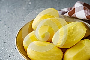 Peeled potatoes on a gray stone background