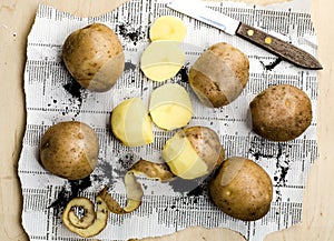 Peeled potatoes with the peel and knife