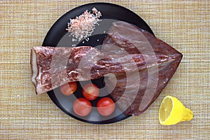Peeled red Kamchatka squid, cherry tomatoes, half a lemon, pink salt - flat lay seafood