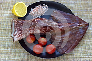 Peeled red Kamchatka squid, cherry tomatoes, half a lemon, pink salt - prepared products for stewing