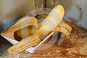 PEELED RIPE BANANA ON AN OLD SHELF