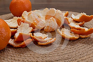 Peeled ripe tangerine in peel close-up on dining table