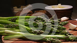 Peeled stems of asparagus fall on the wooden board