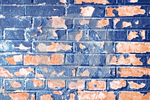 Peeling blue paint on a red brick wall. Blue background