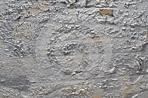 Peeling cracked graffiti paint of silver color on concrete wall