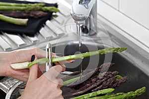 Peeling fresh asparagus in the kitchen