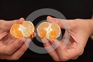 Peeling a Fresh Orange Mandarin. Female Hands skillfully peeling a juicy ripe mandarin