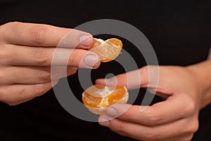 Peeling a Fresh Orange Mandarin. Female Hands skillfully peeling a juicy ripe mandarin