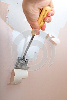 Peeling old latex paint off the wall. Using a scraper to renovate a bathroom