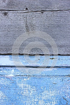 Peeling paint on the old door in the snow. A pattern of rustic blue grunge material. Abstract background.