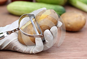 Peeling potato in kitchen