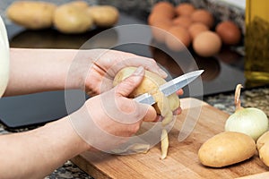 Peeling potatoes on the wooden board