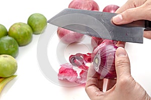 Peeling shallots beside with limes, prepare for cooking