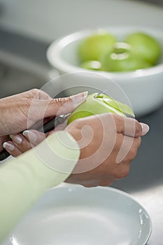 Peeling skin off of green apple using a paring knife