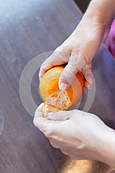 Peeling a tangerine with a woman's hands