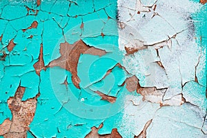 Peeling turquoise paint on a concrete wall. Blue and white painted abstract backgrounds, cracked rusty metal surface, faded