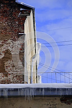 Peeling winter wall with icicles