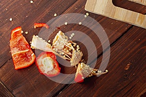 Peels of red sweet pepper, seeds and pepper core on a wooden table