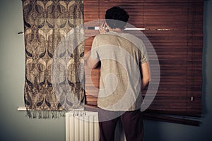 Peeping tom looking through blinds